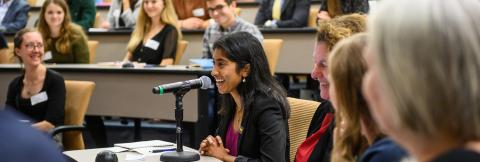 Photo of a student event moderator speaking into a microphone