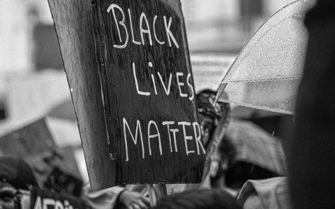 A rainy protest with a sign reading "Black Lives Matter"
