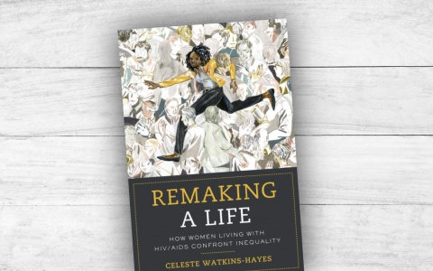 Book cover for "Remaking a Life" atop a white wood plank table.