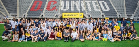 Photo of a group of 100+ Ford School alumni, students, and friends gathered at centerfield in Audi Field, Washington, DC. July 14, 2022.