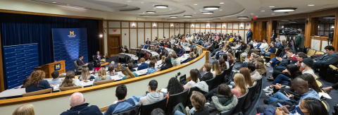 Photo of a full Annenberg Auditorium as Professor John Ciorciari and FBI Director Christopher Wray, at the front of the room, have a conversation at a public event.