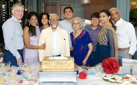 Javed Ali's mother, father, his sister's family, his wife, and son in 2019 in Detroit, smiling and standing around a birthday cake.