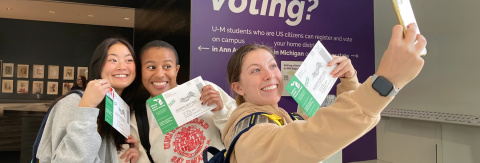 U-M students taking a selfie with their absentee ballots